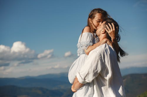 A man surprises his partner with flowers behind his back, symbolizing love and romance.