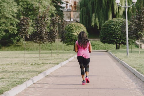 Free Woman in Pink Shirt and Black Leggings Jogging Stock Photo