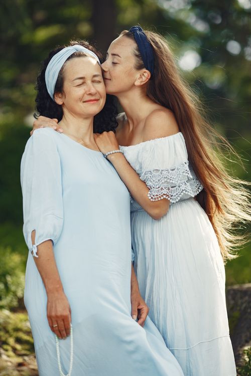 Free A tender moment of affection between a mother and daughter in a serene outdoor setting. Stock Photo