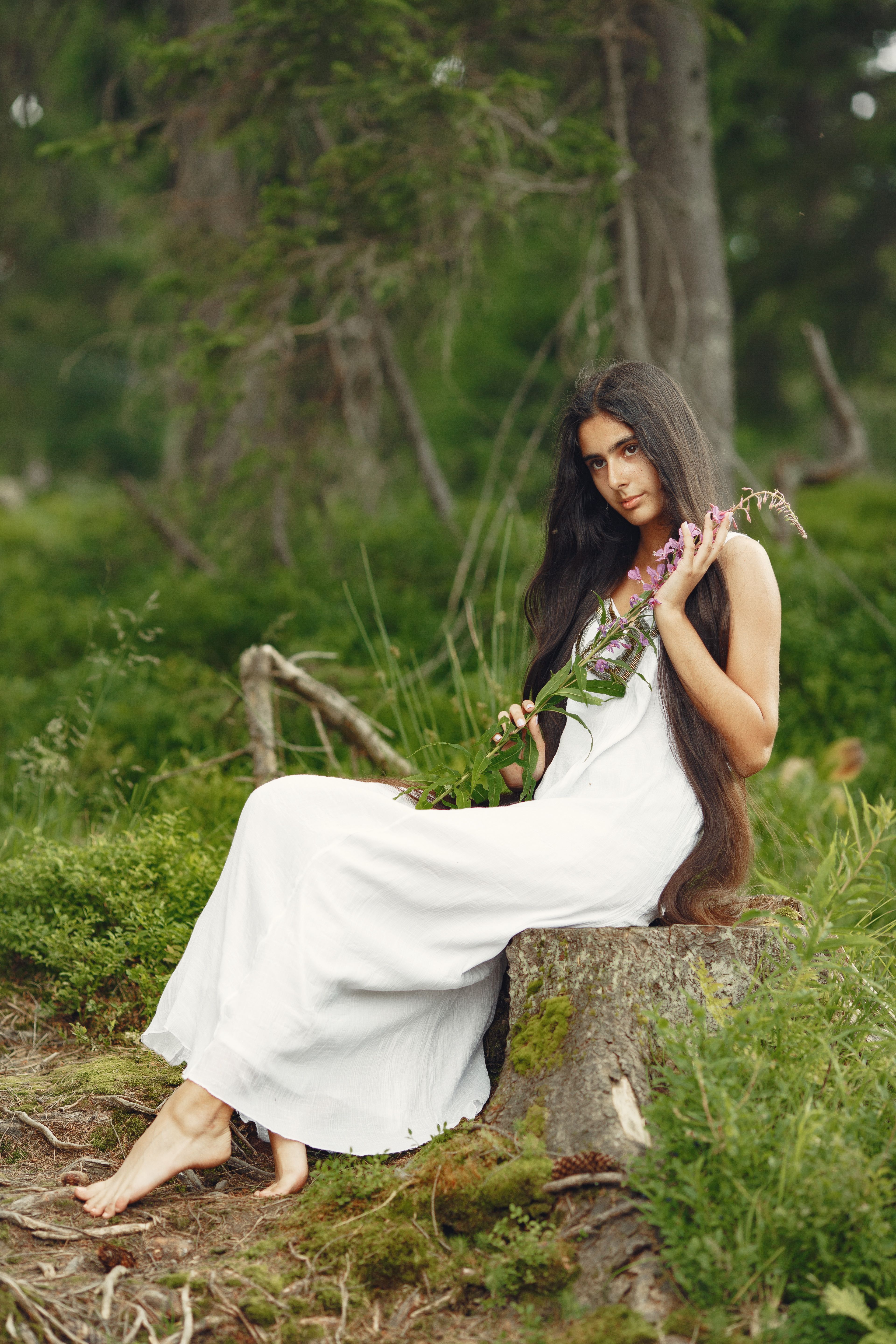 Woman in White Dress Sitting on a Tree Stump · Free Stock Photo