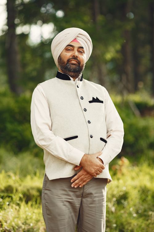 Free Elegant portrait of a turbaned man standing confidently in a natural outdoor setting. Stock Photo