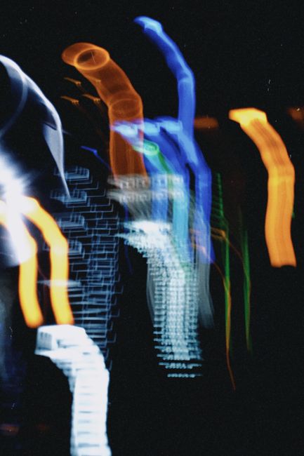Abstract image of vivid neon light trails forming mysterious patterns on a black background.