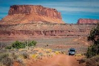 Van on Dirt Road with Butte in Background