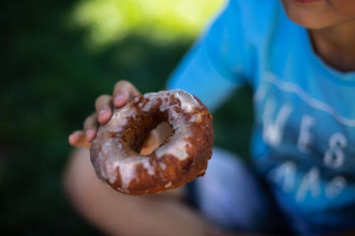 Brown Doughnut on Persons Hand
