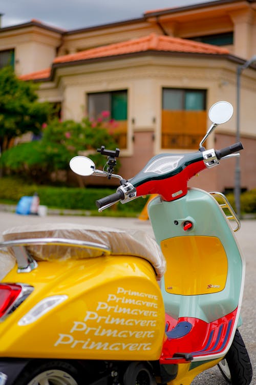 Red and Yellow Motor Scooter Parked on Street