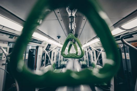 Close-up view of green handles inside an empty Beijing subway train, showcasing urban transit design.