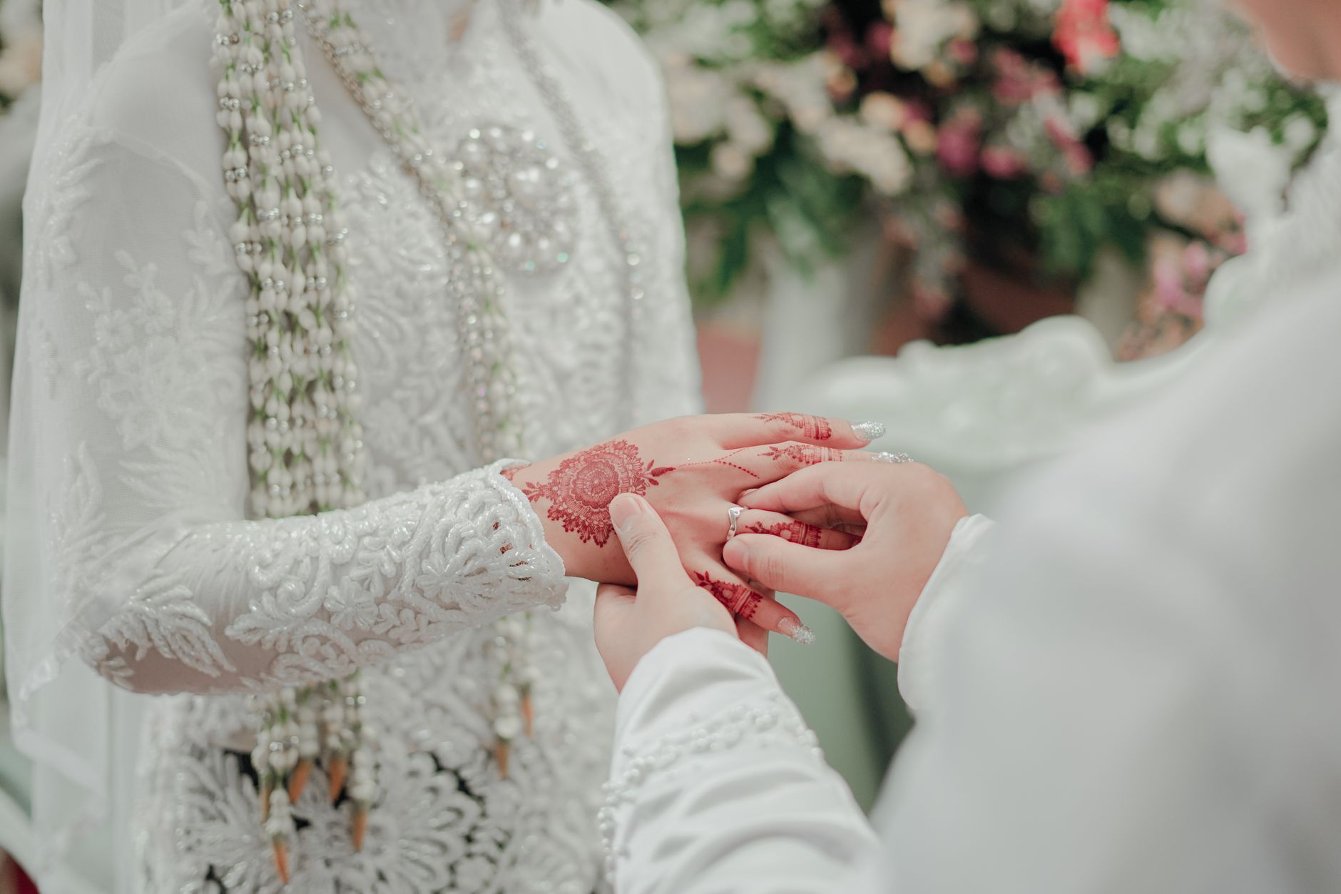 Close-up of mehndi-adorned bride's hands during a traditional wedding ceremony, symbolizing love and unity.