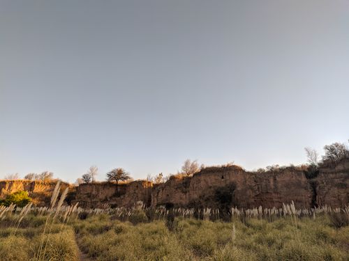 Free Breathtaking landscape featuring rocky cliffs, clear blue sky, and untouched grassland. Stock Photo