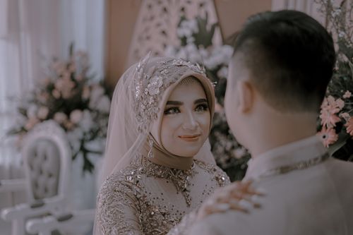 Free A couple in elegant wedding attire sharing a tender moment indoors. Stock Photo