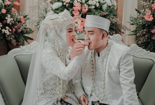 Bride and groom in traditional attire sharing a meal at their wedding ceremony.