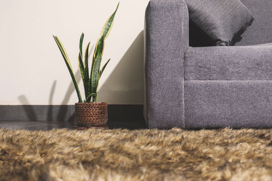 A luxurious faux fur throw draped over a modern sofa.