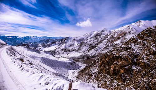 Free A scenic snowy mountain range under a clear blue sky, perfect for winter travel. Stock Photo
