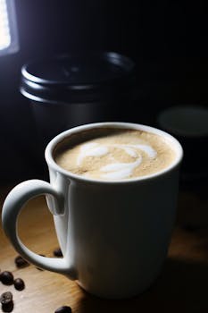 Close-up of a latte with foam art in a white ceramic mug, creating a warm atmosphere.