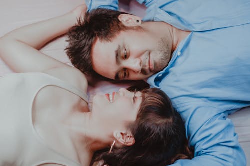 Happy Asian couple lying on bed