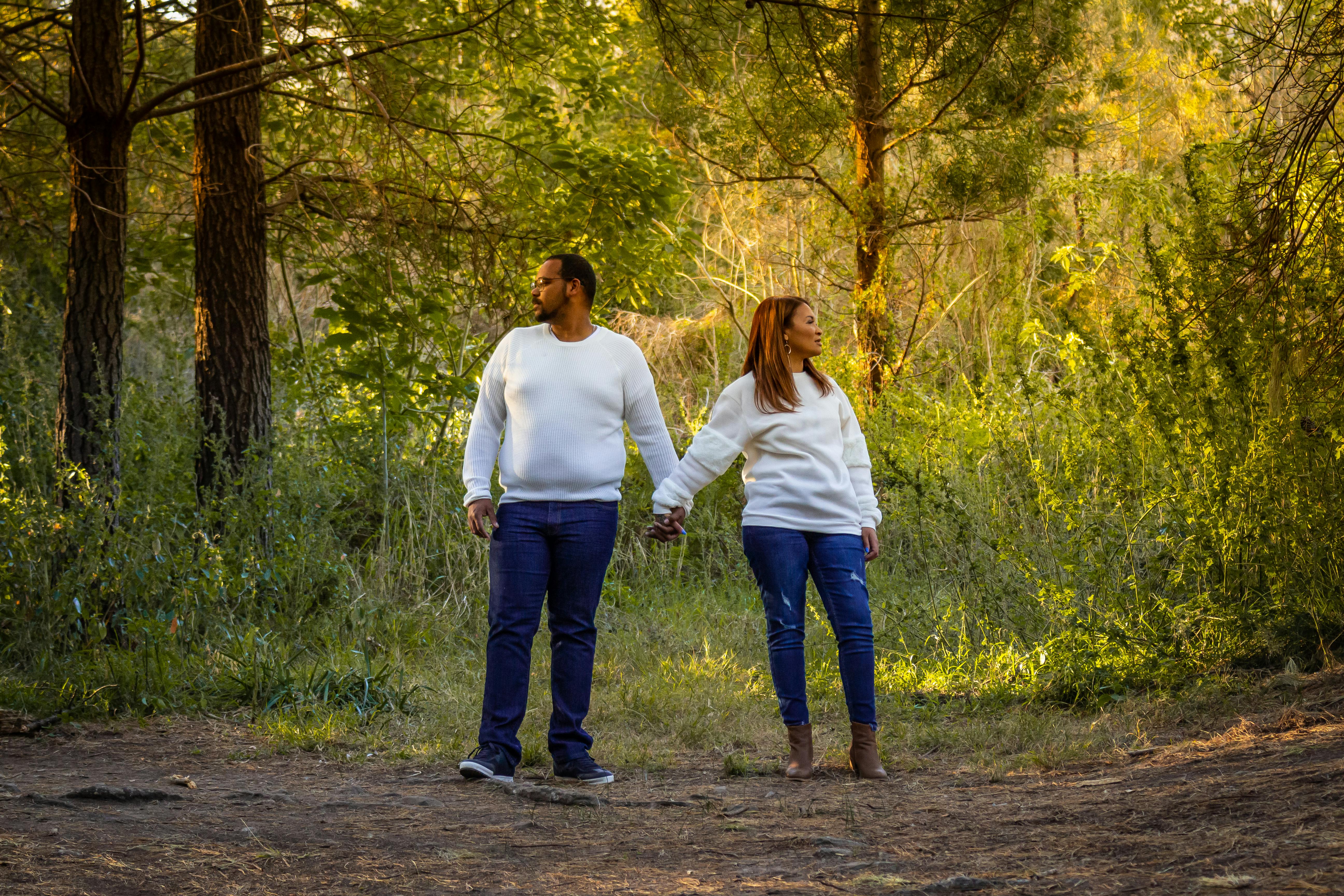 man in white long sleeve shirt and blue denim jeans standing beside woman in white long sleeve sweater