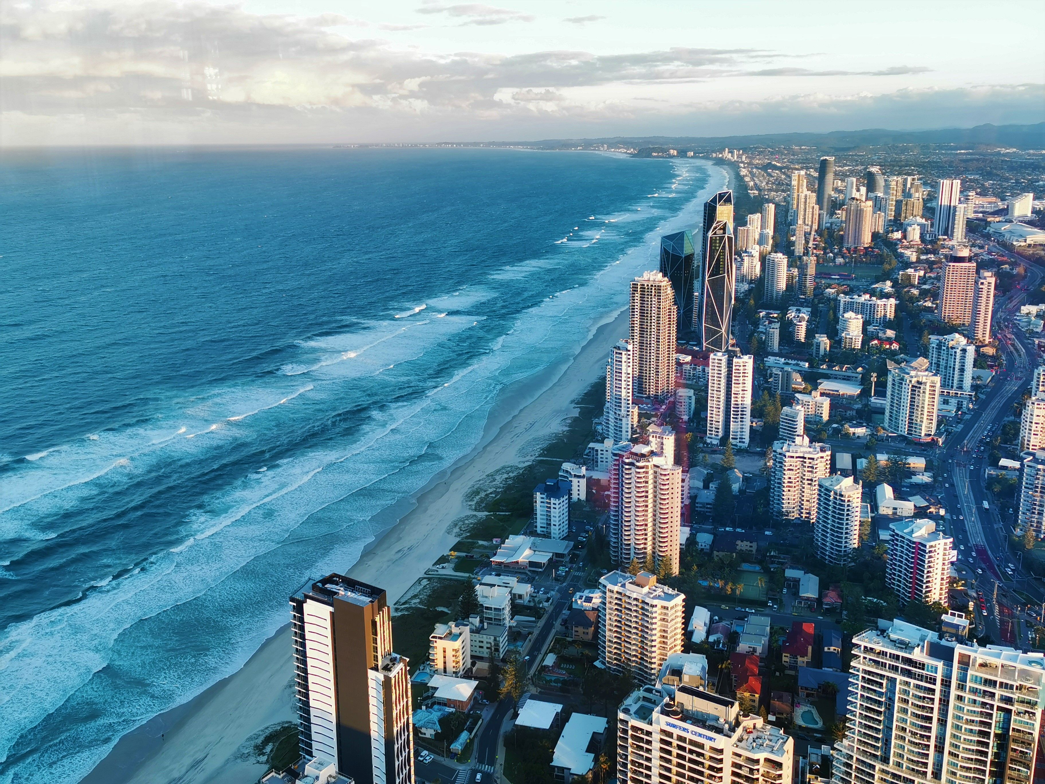 Stunning aerial view of Gold Coast, QLD, showcasing its skyscrapers and beautiful beach at daylight.