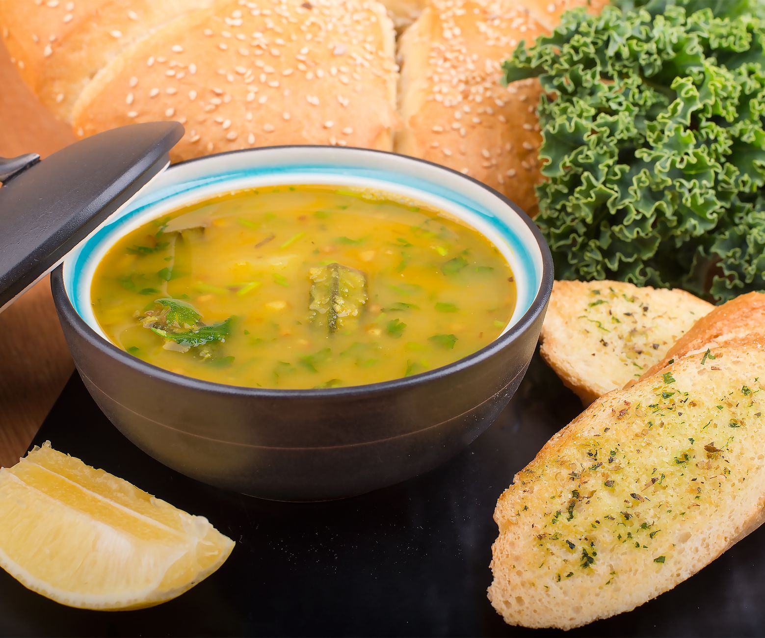Bowl of sausage, kale, and lentil soup garnished with cheese