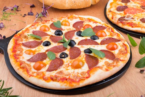 Free Pizza With Green Leaves on Top Stock Photo