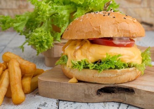 Burger With Lettuce and Tomato on Brown Wooden Chopping Board