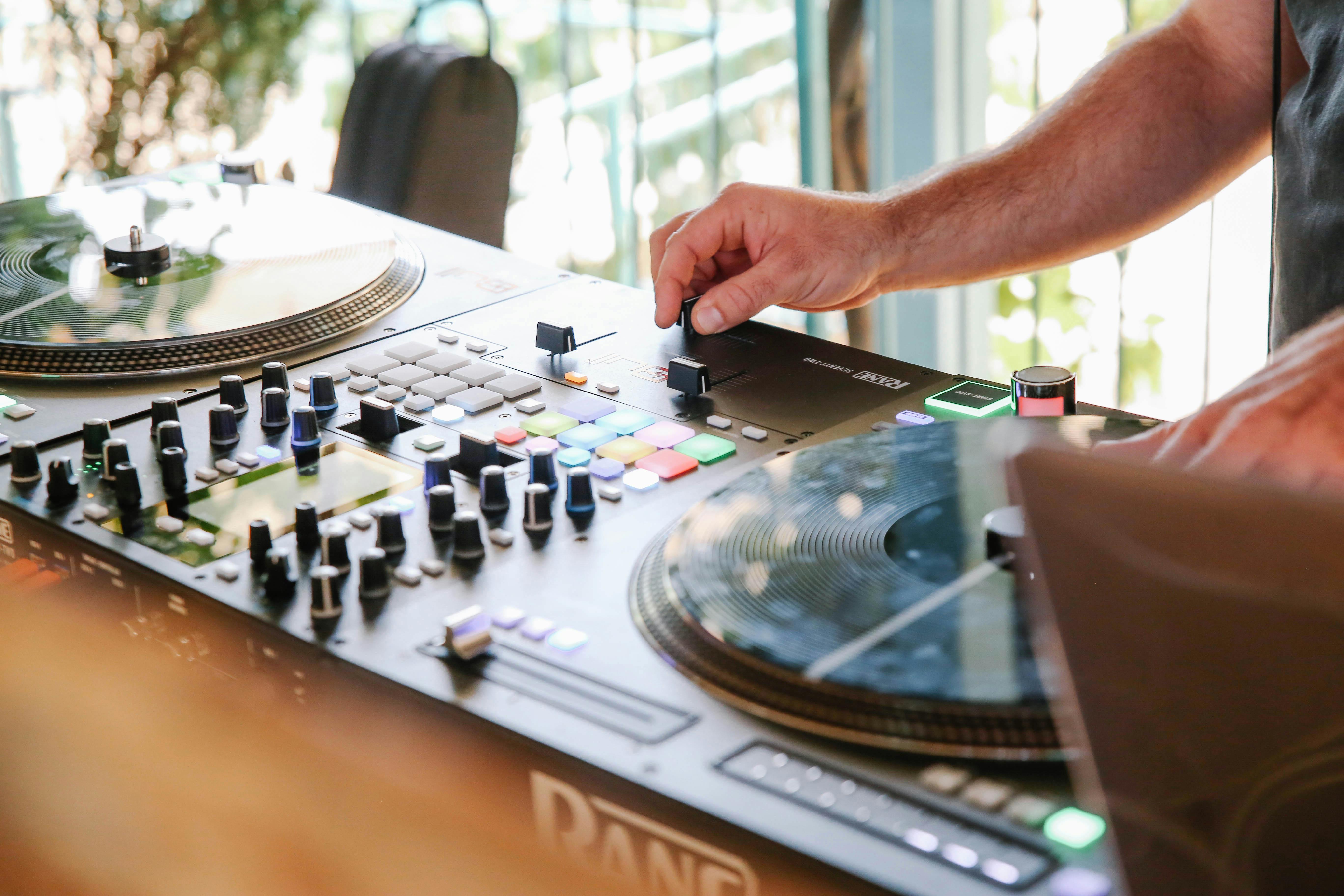 person playing with black dj mixer