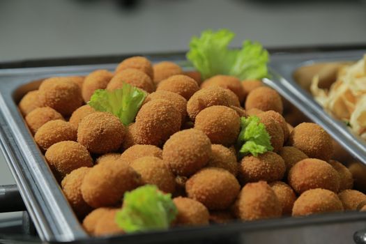 Delicious fried appetizers served on a metal tray, garnished with fresh lettuce.