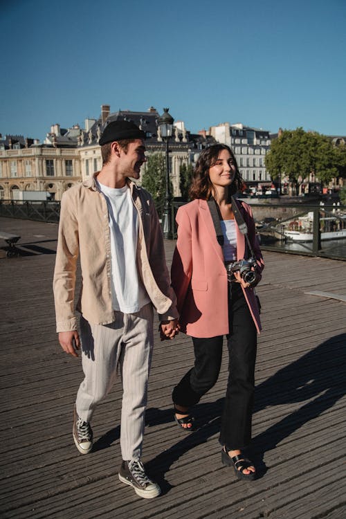 Free Man in Beige Button Up Shirt and Pants Standing Beside Woman in Pink Blazer Stock Photo