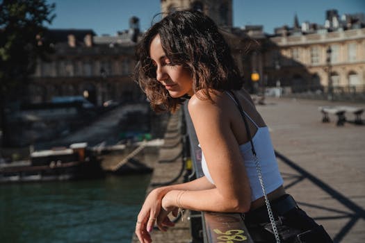 一名年轻女子在阳光明媚的日子里，于城市景观背景的桥上享受时光