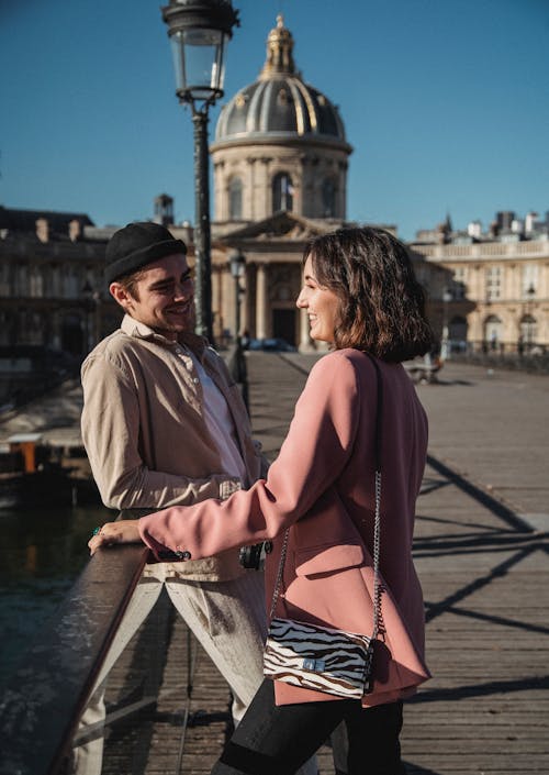 Man Leaning on a Railing Looking at a Woman