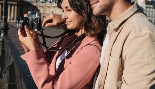 Free A loving couple enjoying a sunny day while capturing memories with a camera. Stock Photo
