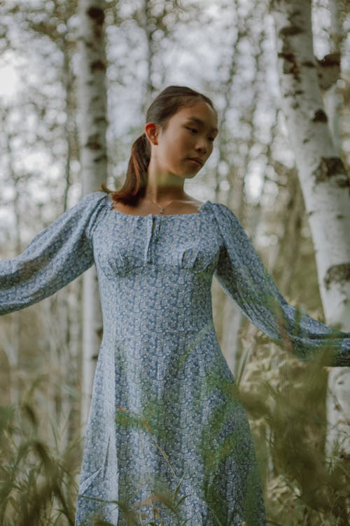 Graceful ethnic woman in dress in forest