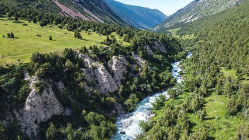 Free Stunning aerial perspective of a river flowing through lush green mountains and dense forest in the countryside. Stock Photo