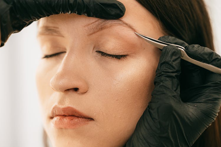 Person Plucking Woman's Eyebrow