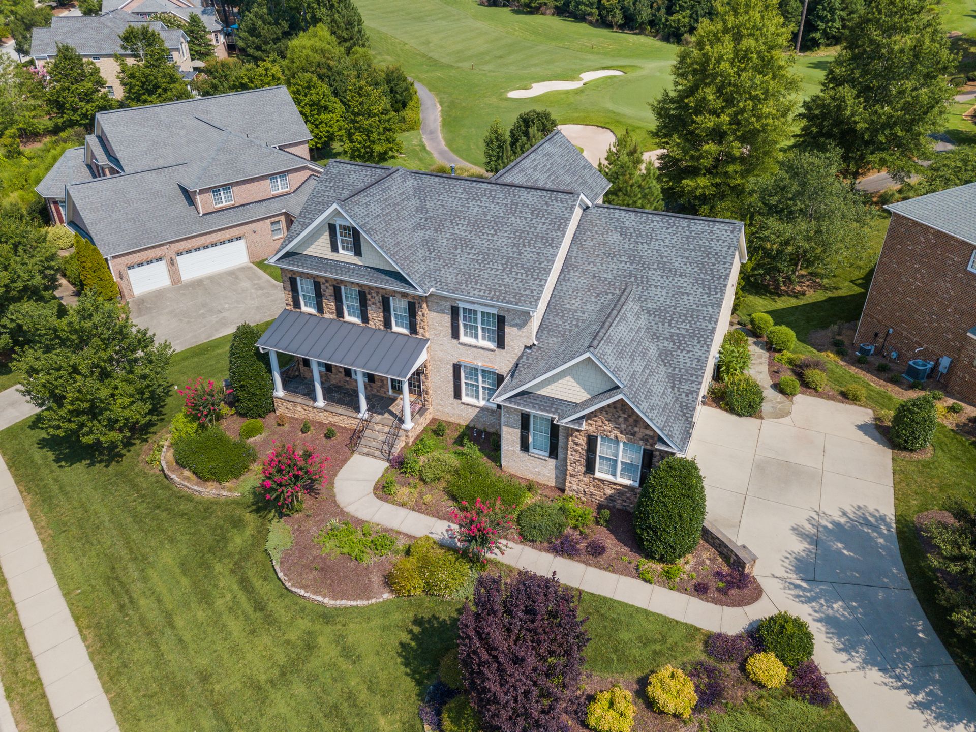 Aerial view of a house with a lush, well-maintained green lawn