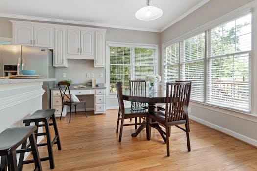Spacious kitchen dining area with wooden furniture and large windows.