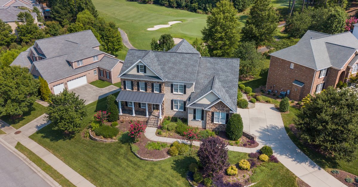 Aerial view showcasing a suburban home adjacent to a lush golf course in Raleigh, NC.