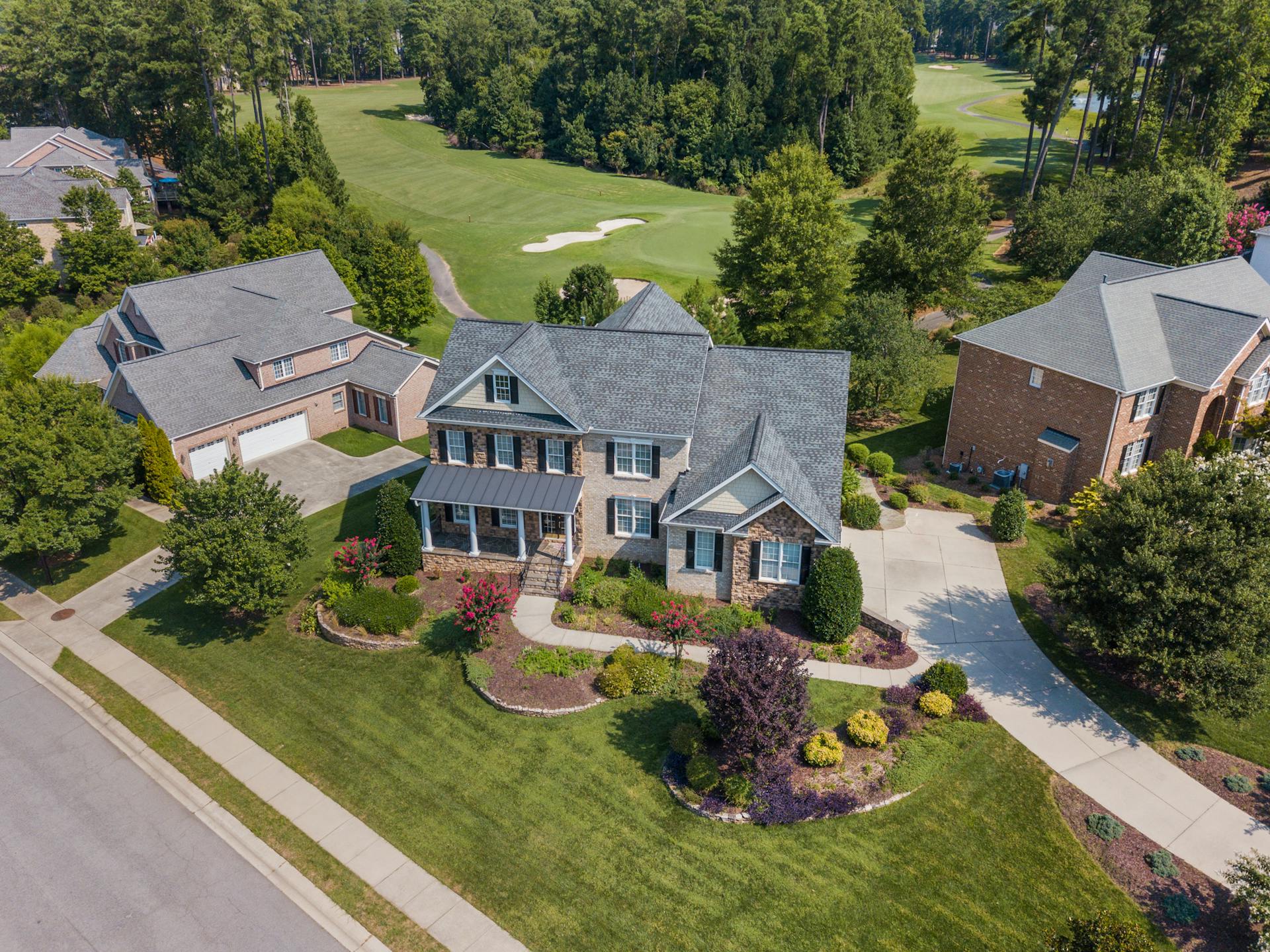 Aerial view showcasing a suburban home adjacent to a lush golf course in Raleigh, NC.