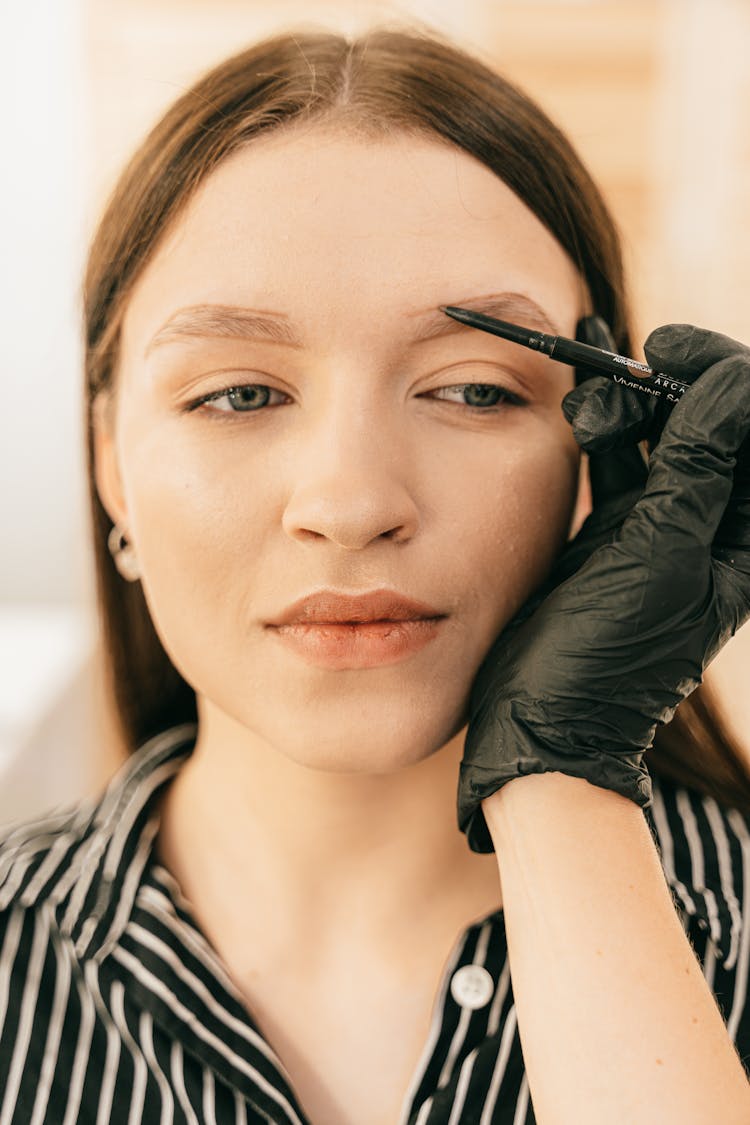 Woman In Black And White Stripe Shirt Getting Her Eyebrows Done