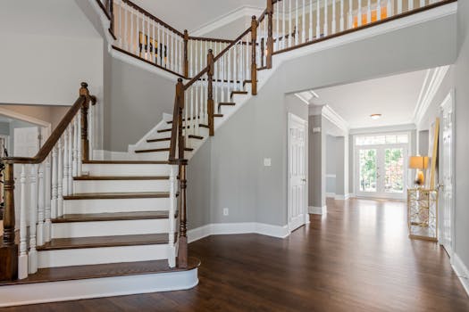 Bright and spacious entryway with wooden staircase and natural lighting.