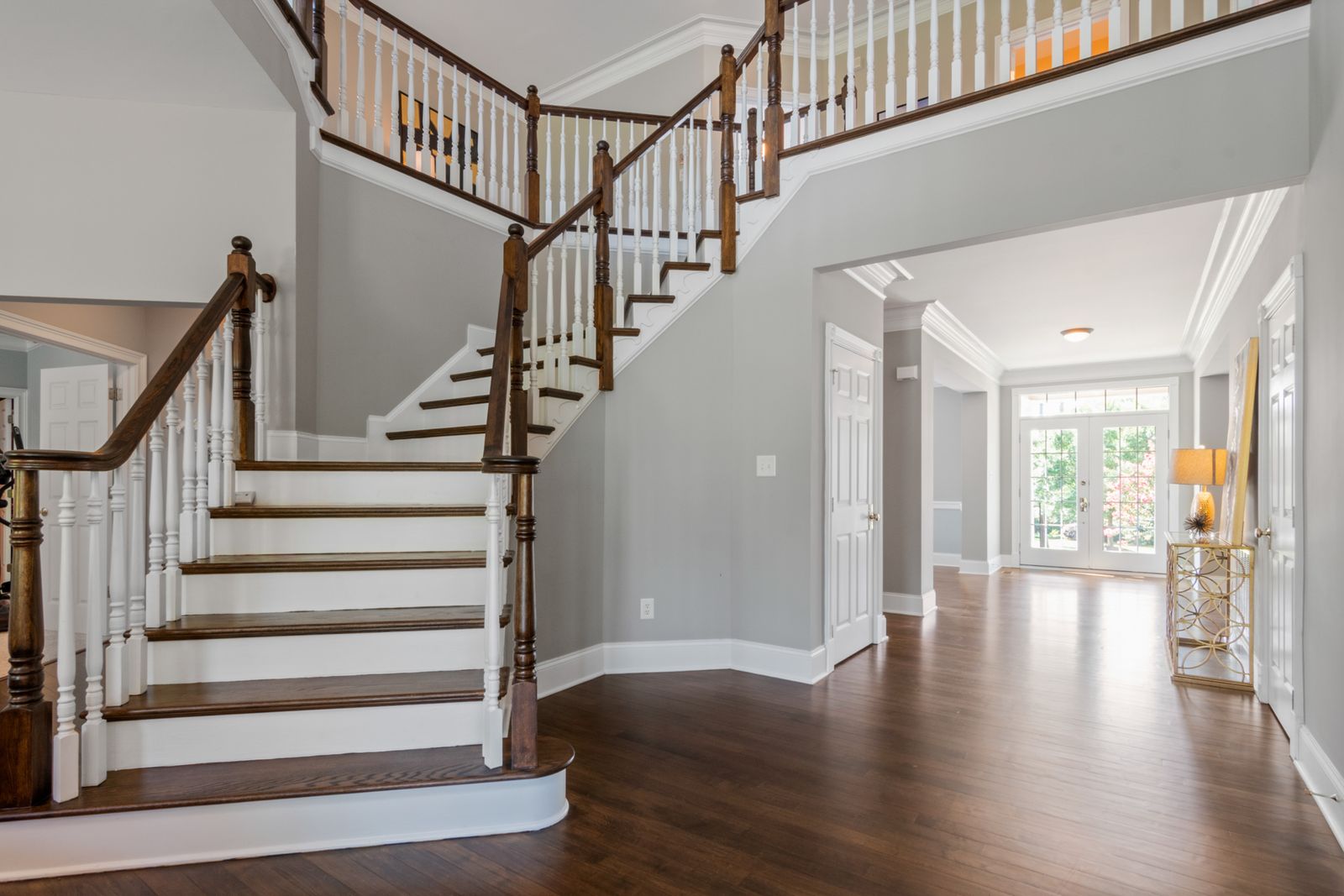 Entry hall with a turned staircase and dark hardwood floor — photo by Curtis Adams on Pexels