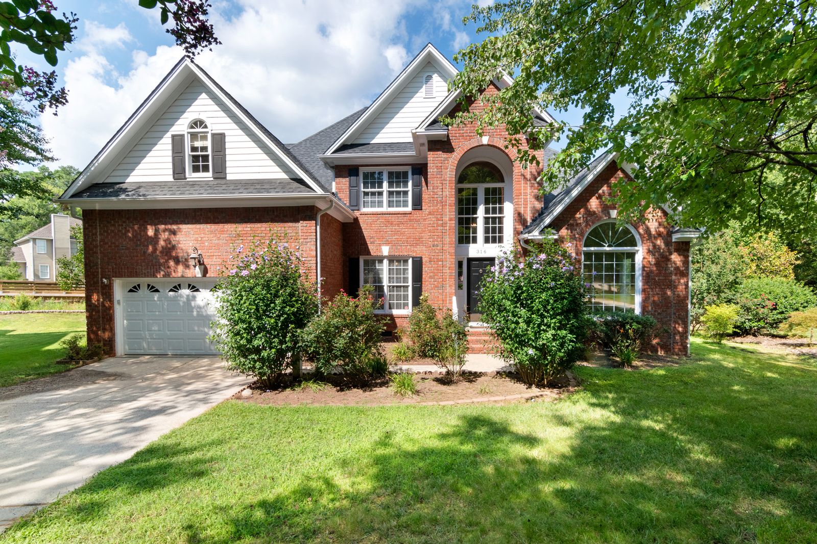 Concrete driveway at a red brick suburban home