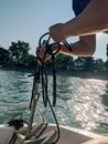 Crop person with anchor on boat in sea