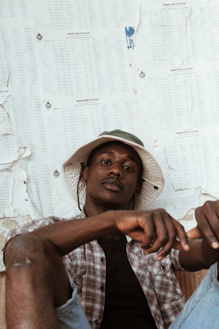 Trendy African Man In Panama Hat Near Paper Wall