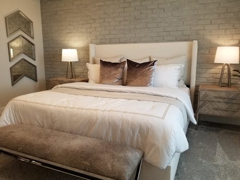 Stylish bedroom featuring a plush bed, decorative lamps, and contemporary decor.