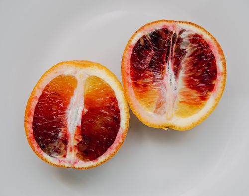 Free Top view of halves of juicy tasty sliced healthy red orange placed on white background Stock Photo