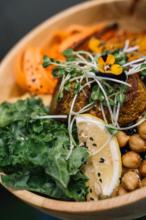 Free Vibrant vegan Buddha bowl featuring fresh veggies, chickpeas, and lemon slices. Stock Photo