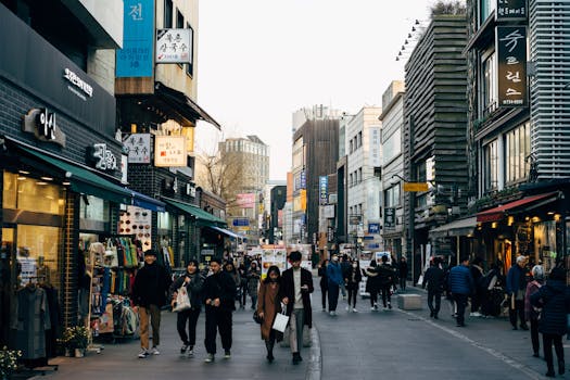 Lively shopping street in Seoul with people walking, shops, and vibrant city life.