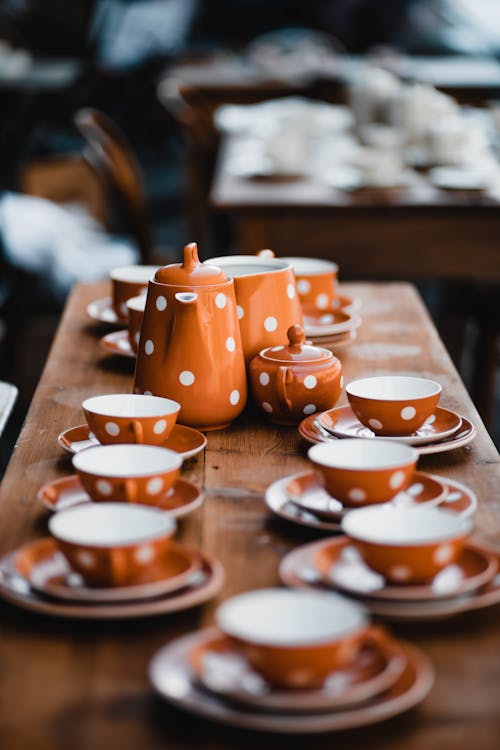 Orange and White Ceramic Tea Cups on Brown Wooden Table