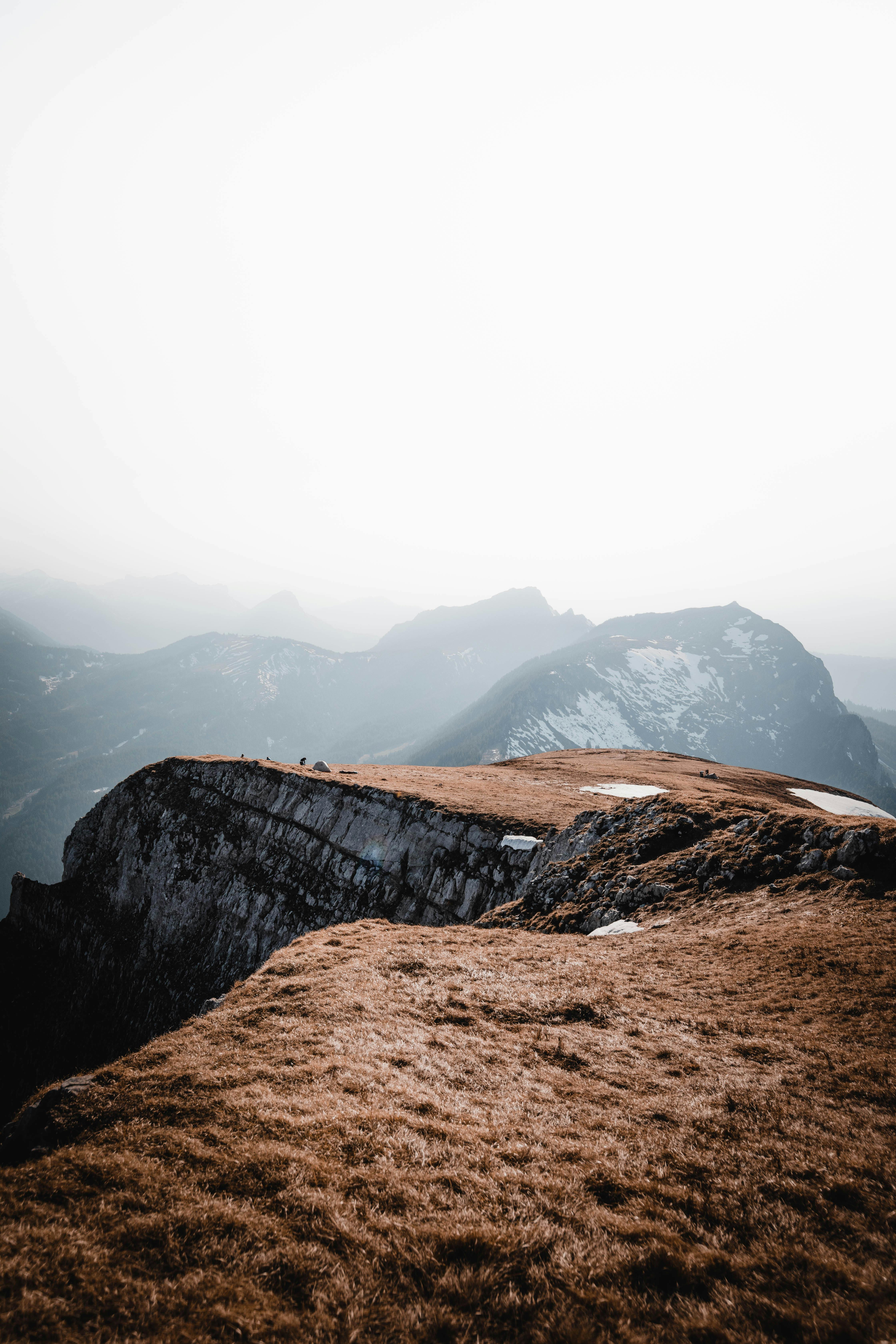 Breathtaking view of a foggy Alpine landscape in Switzerland, showcasing rugged cliffs and serene beauty.