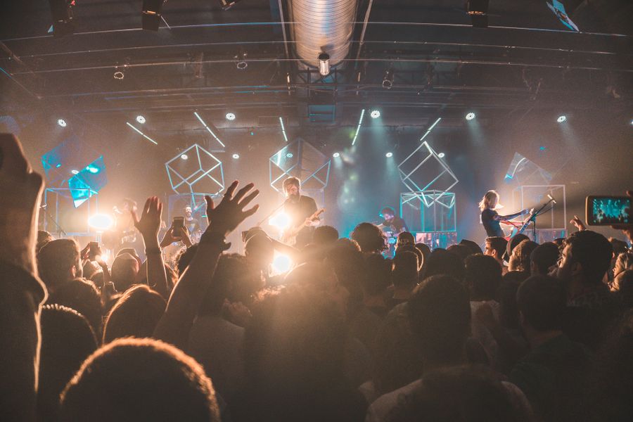 Band playing to a full room under stage lights — photo by Kaique Rocha on Pexels