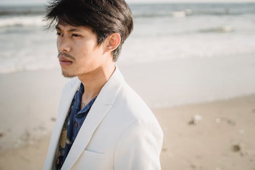 Man in White Suit Jacket Standing on Beach
